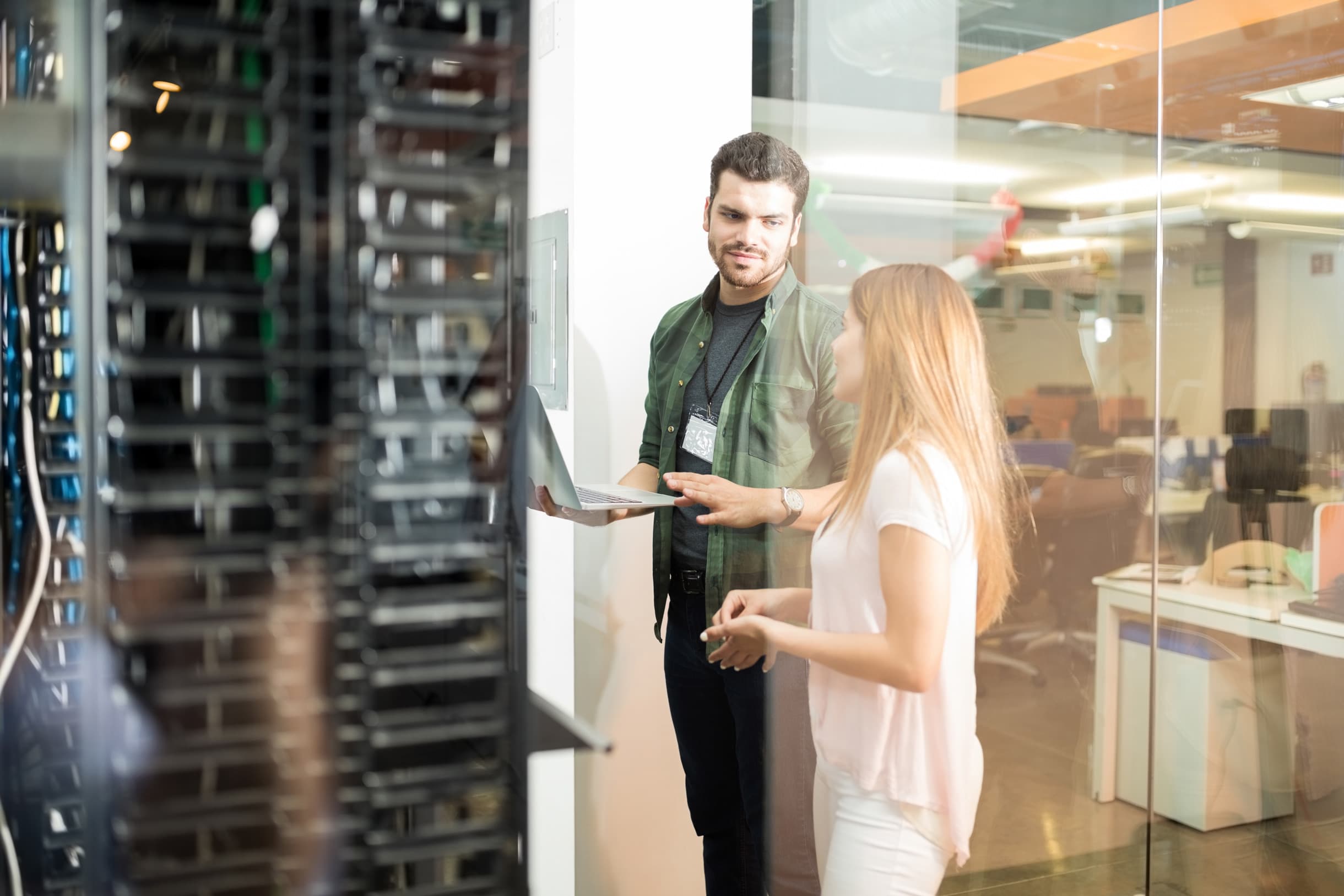 Two people in a server room discussing infrastructure